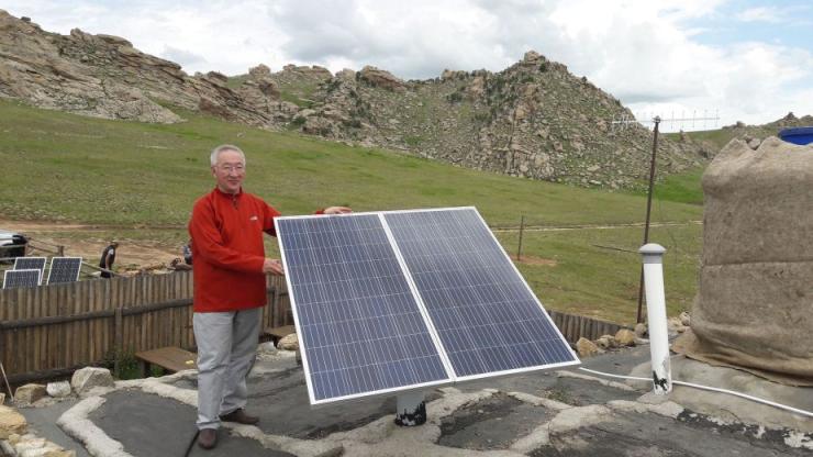 Mann mit Solarpanel in der Mongolei